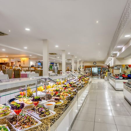 Sealife Family Resort Hotel Antalya Exterior foto The photo shows a spacious dining area, likely a buffet or restaurant, featuring a wide array of colorful food presentations. There are multiple serving stations with neatly arranged dishes, including a variety of salads, appetizers, and desserts. Th