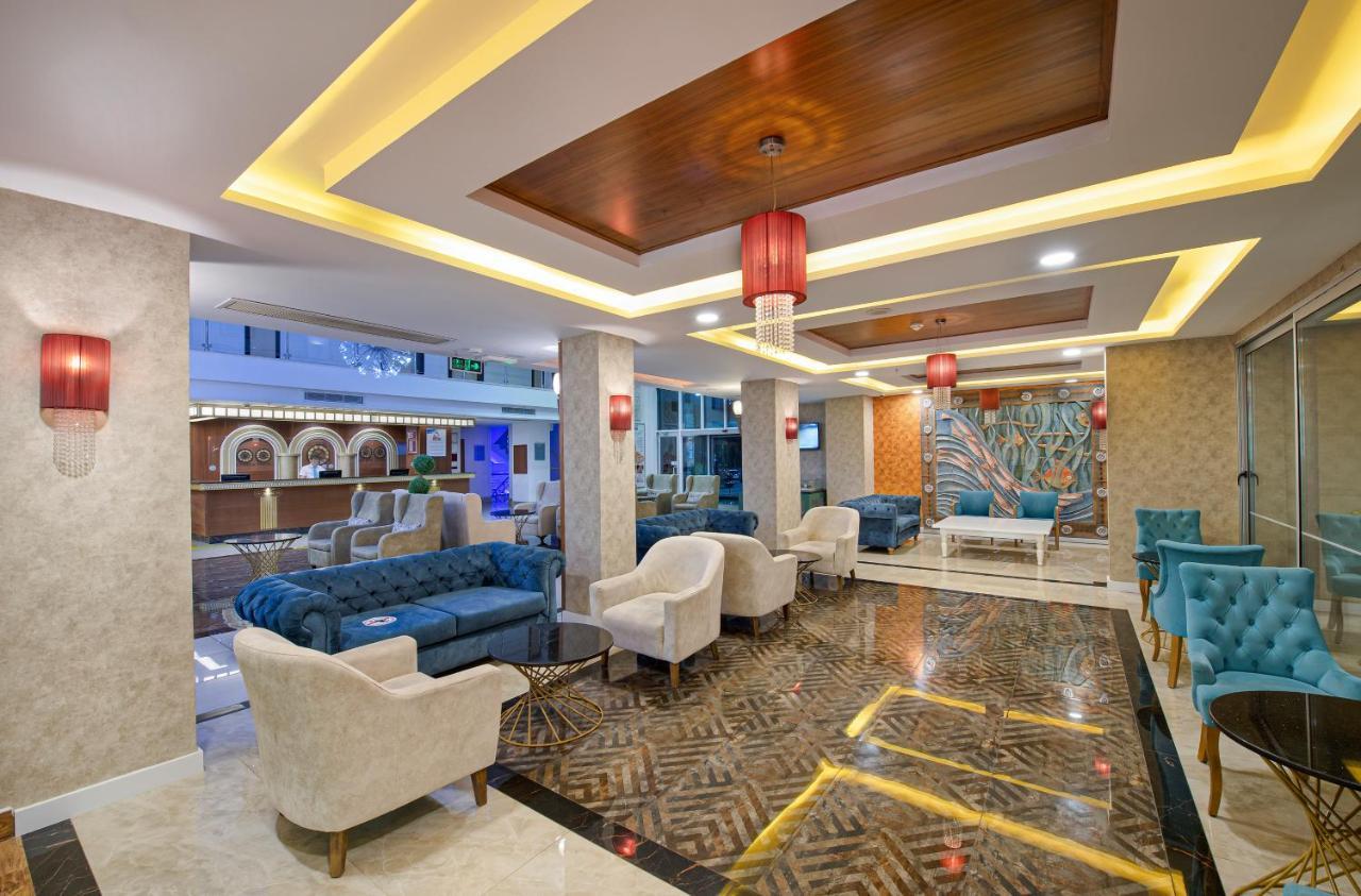 Sealife Family Resort Hotel Antalya Exterior foto The photo showcases a stylish and modern lounge area, featuring a mix of comfortable seating options. There are plush sofas in shades of blue and cream, along with elegant armchairs. The space is well-lit, with recessed lighting and decorative red pe