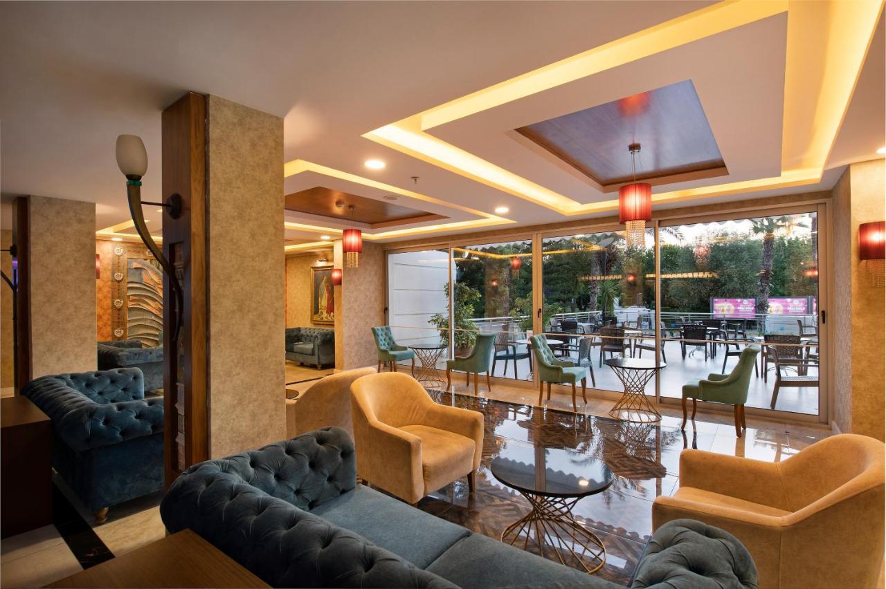 Sealife Family Resort Hotel Antalya Exterior foto The photo shows a modern and stylish lounge or café area. It features comfortable seating arrangements with plush sofas in shades of blue and beige. The interior is well-lit with decorative ceiling lights and elegant pendant lamps hanging above. Larg
