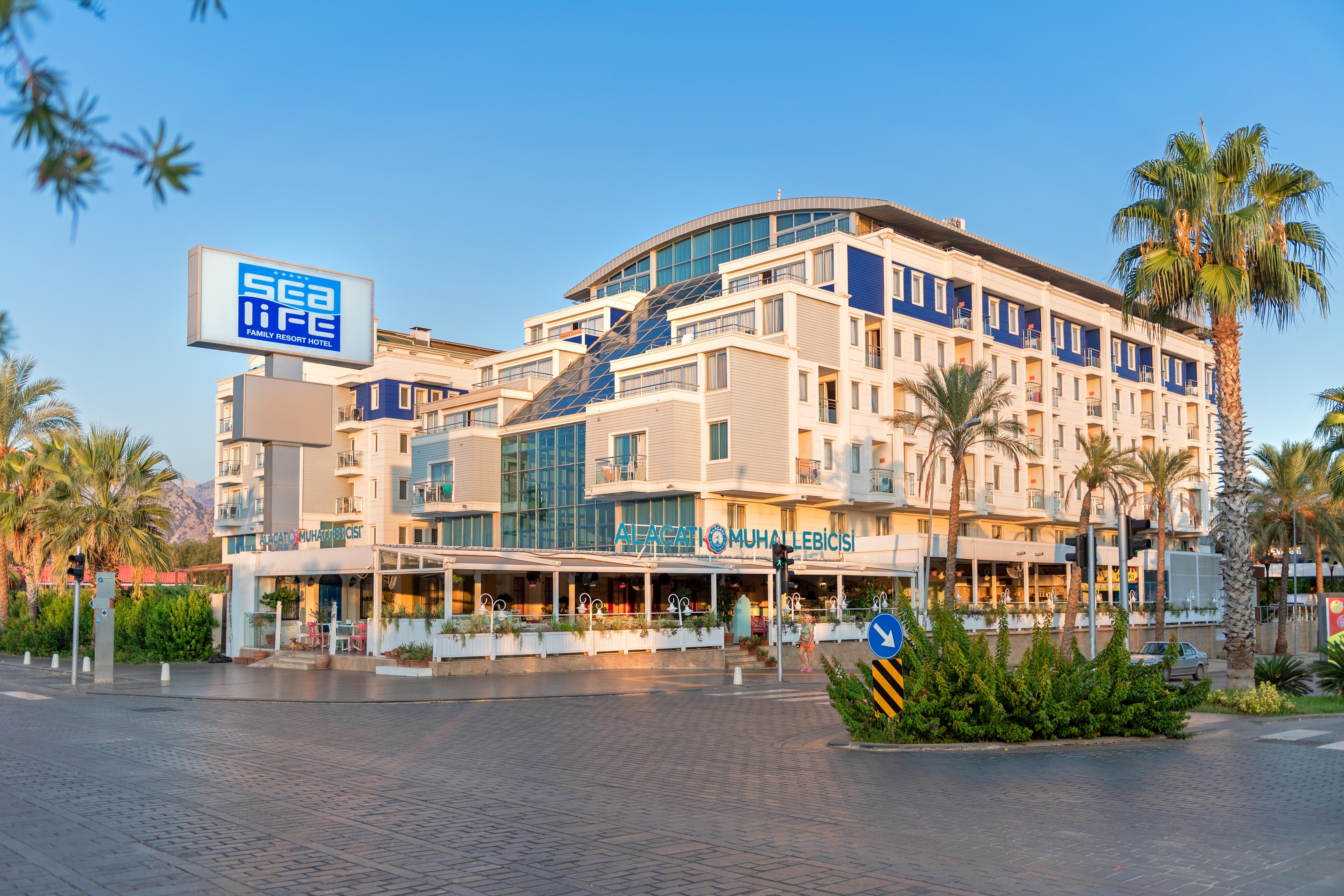 Sealife Family Resort Hotel Antalya Exterior foto The photo shows a modern building with a contemporary architectural design, featuring multiple levels and large glass windows. There is a sign that reads "sea life" prominently displayed on the left. The building appears to house a restaurant or café