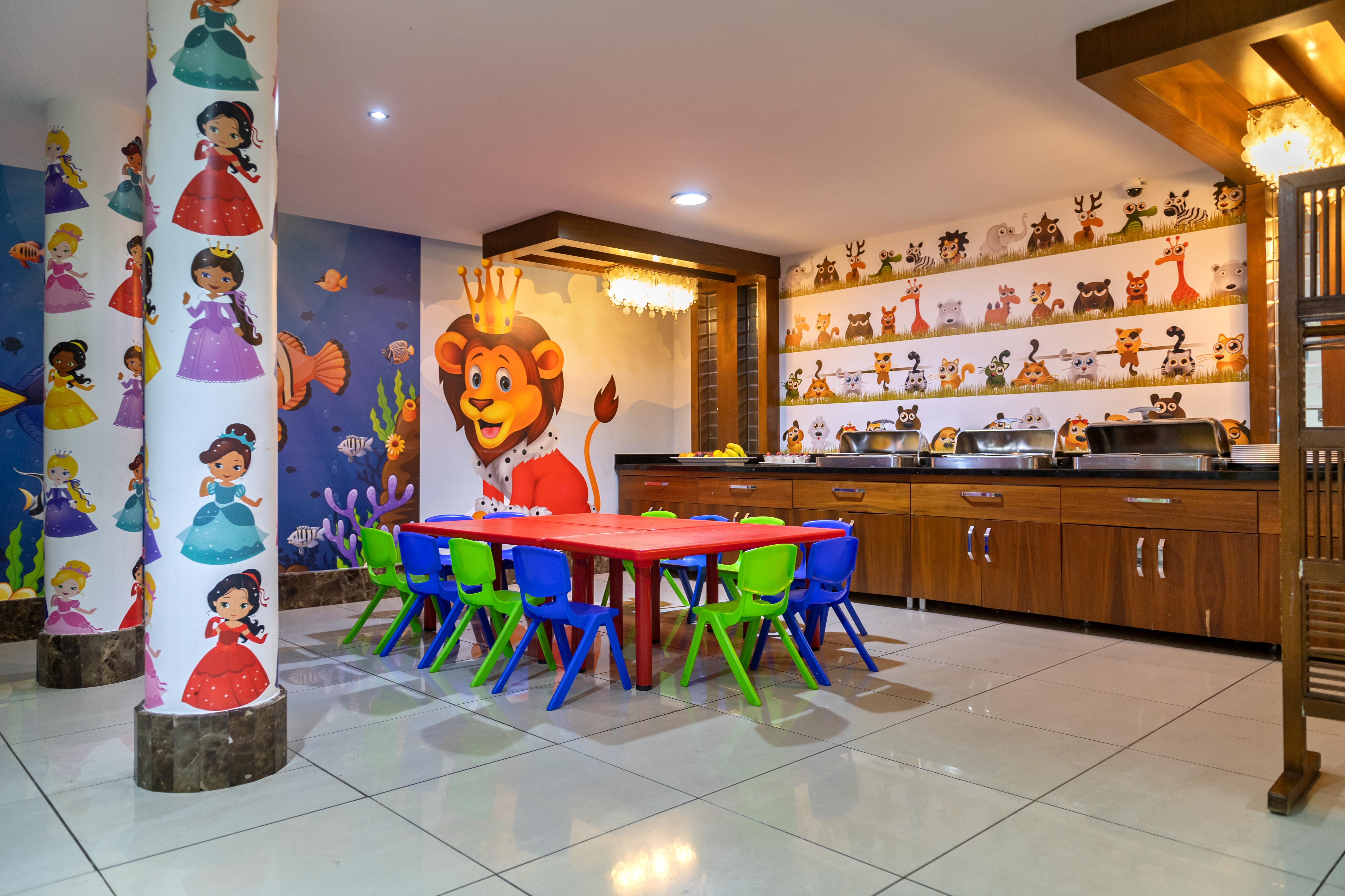 Sealife Family Resort Hotel Antalya Exterior foto The photo shows a vibrant children's playroom or activity area. There is a red table surrounded by small chairs in various colors (blue and green). The walls are decorated with colorful murals, including images of cartoon characters, animals, and pri