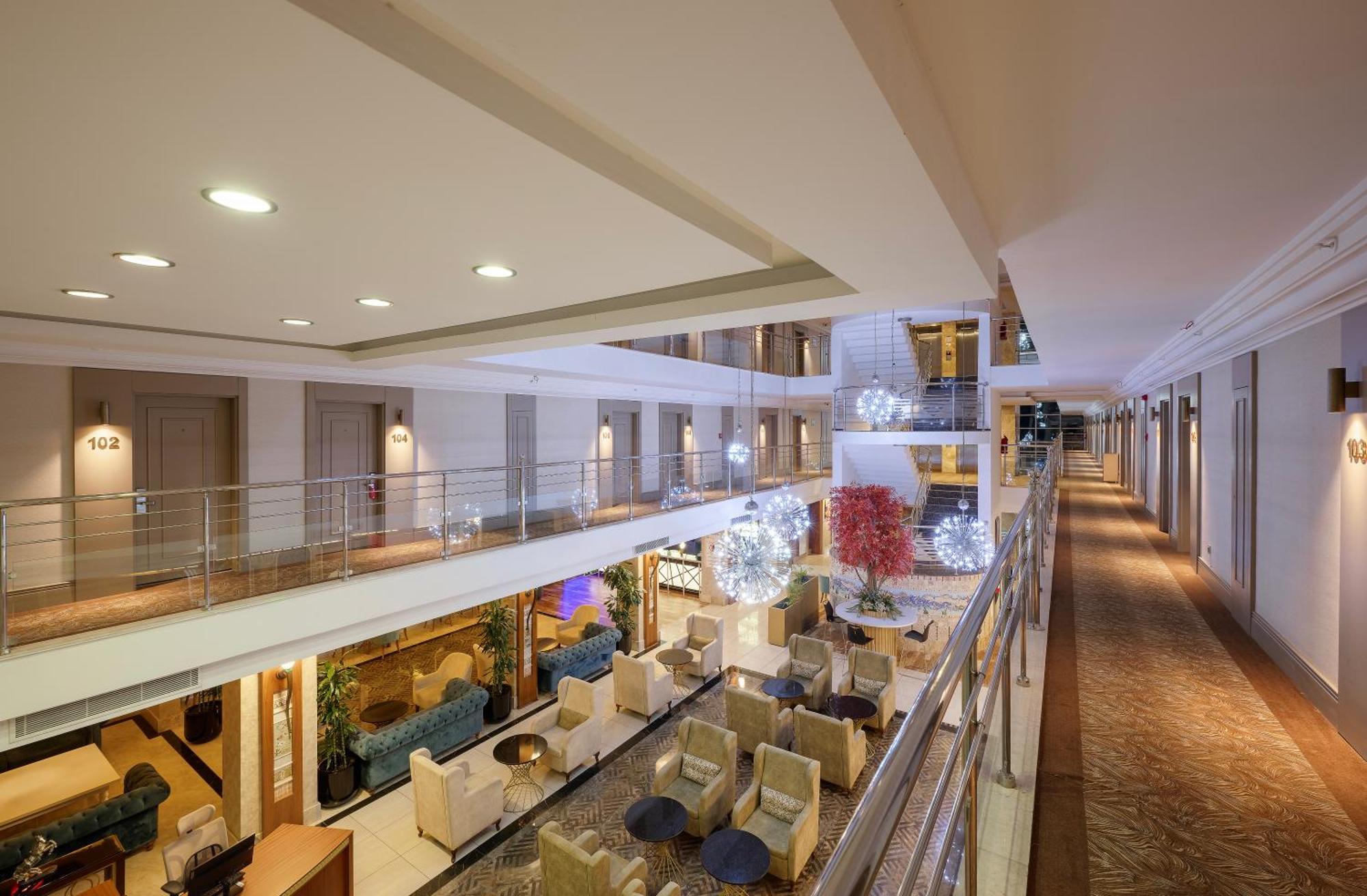 Sealife Family Resort Hotel Antalya Exterior foto The photo shows the interior of a hotel or a similar building. It features a wide corridor flanked by various rooms, with a modern and elegant design. In the center, there is a seating area with plush chairs and tables, creating a cozy atmosphere. De