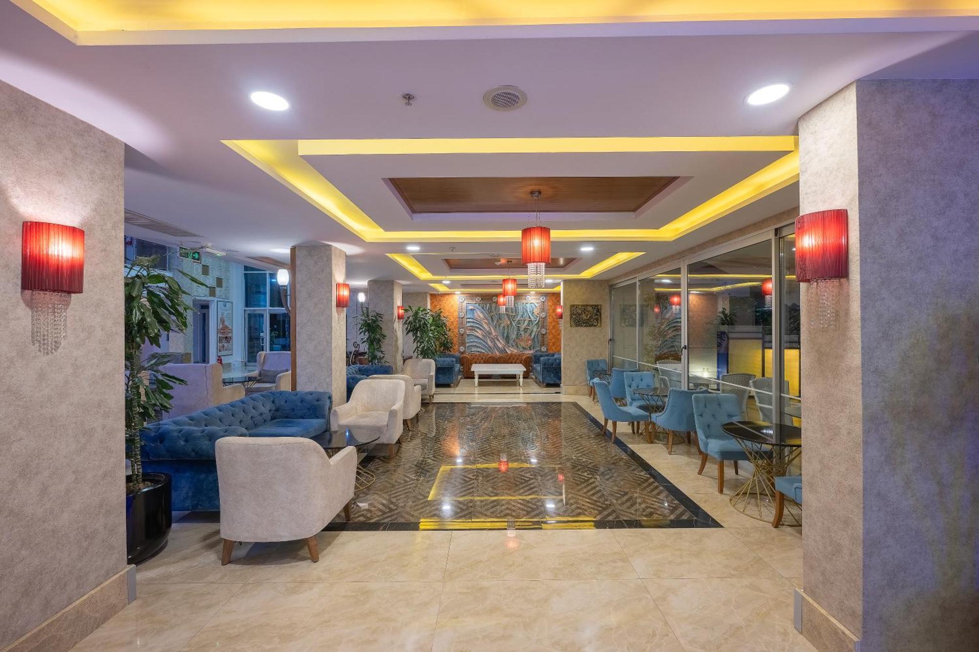 Sealife Family Resort Hotel Antalya Exterior foto The photo shows a modern lobby area, characterized by stylish decor and a welcoming atmosphere. There are comfortable seating arrangements with blue upholstered chairs and white armchairs. The flooring appears to be a polished stone, complemented by 